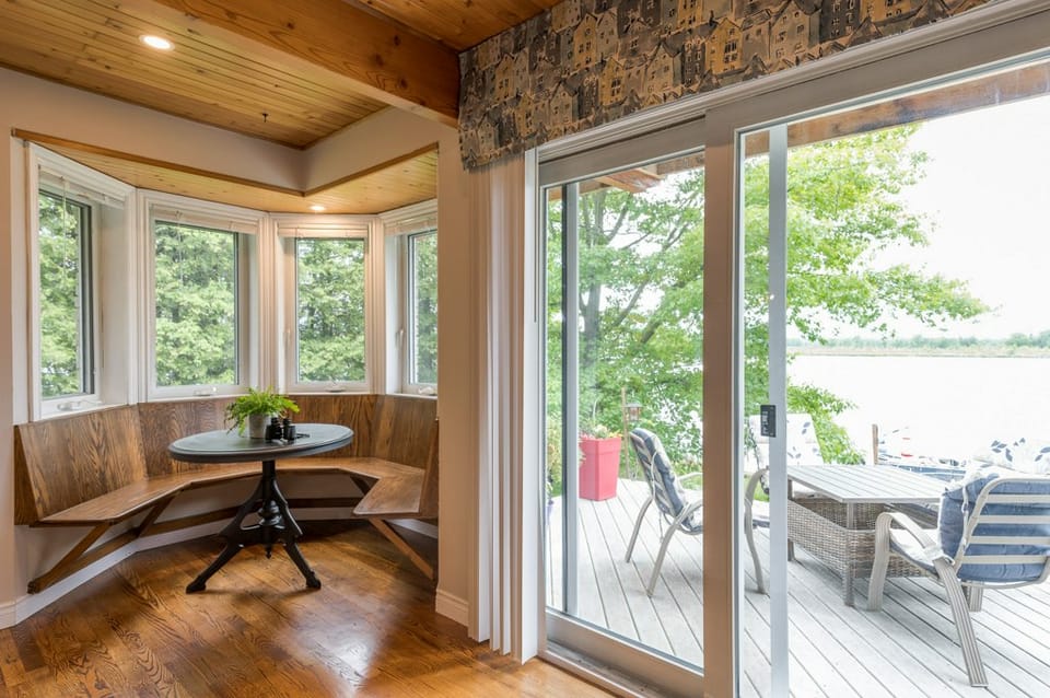 The breakfast corner, bay windows open to the lake deck